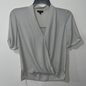 A light Gray loose fitting Topshop women’s short sleeved top. Size 6